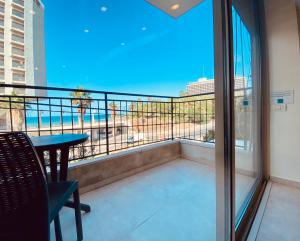 balcón con mesa y vistas al océano en White Gordon Beach Apartment, en Tel Aviv