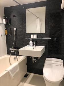 a bathroom with a sink and a toilet and a mirror at HOTEL SUI AKASAKA by ABEST in Tokyo