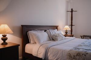 a bedroom with a bed with pillows and two lamps at Tudor Barn - Little England Cottages in Nuwara Eliya