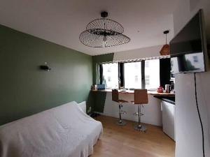 - une chambre avec un lit blanc dans un mur vert dans l'établissement Vannes: charmant studio sur le port, à Vannes