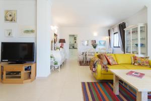 - un salon avec un canapé jaune et une télévision dans l'établissement Penthouse Acapulco, à Fuengirola