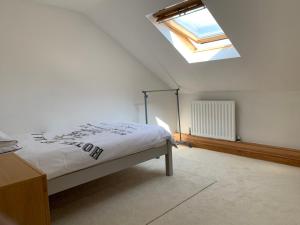 Schlafzimmer mit einem Bett und einem Dachfenster in der Unterkunft Fabulous loft, great views in Buxton