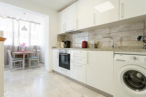 a kitchen with white cabinets and a washer at Apartamento Terrazas de la Veguilla in Fuengirola