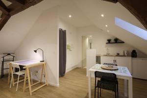 a kitchen with a table and chairs and a table and a counter at Studio neuf cosy La flèche in La Flèche