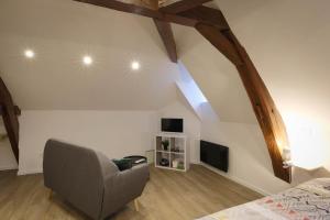 ein Schlafzimmer mit einem Bett und einem Stuhl in einem Zimmer in der Unterkunft Studio neuf cosy La flèche in La Flèche