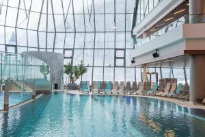 a swimming pool in a building with chairs at Aqua Dome 4 Sterne Superior Hotel & Tirol Therme Längenfeld in Längenfeld