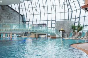 a swimming pool in a building with a glass ceiling at Aqua Dome 4 Sterne Superior Hotel & Tirol Therme Längenfeld in Längenfeld