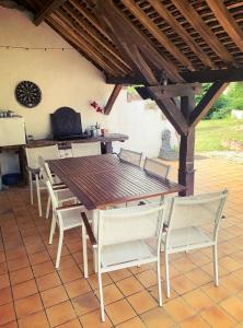 einen Holztisch und Stühle auf einer Terrasse in der Unterkunft Week-End au Vert in Voisines