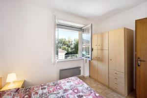 un dormitorio con una cama y una ventana en Villa Paola Bilo4, en Loano