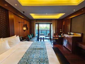a hotel room with a large bed and a desk at Sanya LUHUITOU Resort & Spa in Sanya