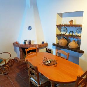een eetkamer met een tafel en een open haard bij Casa Alameda in Benarrabá