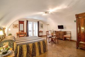 a bedroom with a bed and a desk and a television at Navona Gallery Suites in Rome