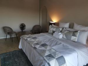 um quarto com uma cama grande e 2 cadeiras em THE THATCH HIDE em East London