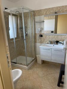 uma casa de banho com um chuveiro e um lavatório. em Hotel La Campagnola em Capo Vaticano