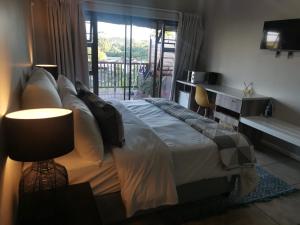 sypialnia z łóżkiem, biurkiem i oknem w obiekcie THE THATCH HIDE w mieście East London