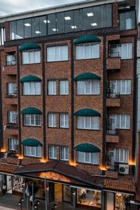 a large brick building with windows and a roof at HASUNİ TAŞ HOTEL in Diyarbakır