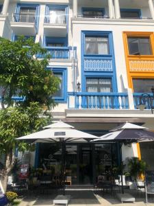 due ombrelloni e tavoli e sedie di fronte a un edificio di Liên’s Mini Hotel a Phu Quoc