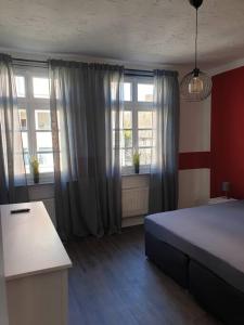 1 dormitorio con 1 cama, 2 ventanas y escritorio en Ferienwohnung Leonie, en Goslar