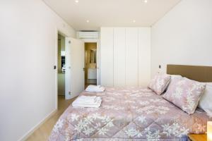 una camera con letto e copriletto rosa di Apartamento Porlamar a Quarteira