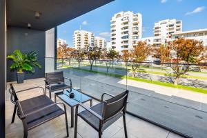 balcone con sedie, tavolo e vista sulla città di Apartamento Porlamar a Quarteira