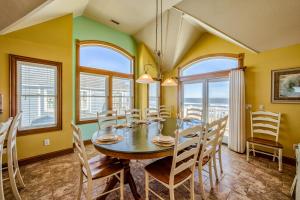 a dining room with a table and chairs and windows at Coastal Charm 220 in Avon