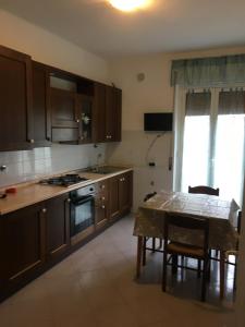 uma cozinha com armários de madeira e uma mesa com uma sala de jantar em Appartamento MIRAMARE em Ventimiglia