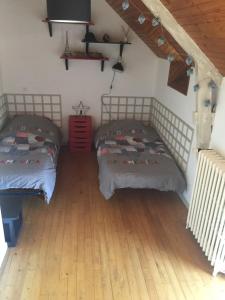 2 camas en una habitación con suelo de madera en Gîte à la campagne, en Pontchâteau