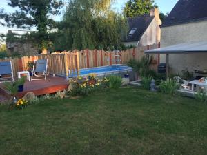 un patio trasero con terraza de madera y piscina en Gîte à la campagne, en Pontchâteau