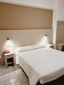 een slaapkamer met een groot wit bed en 2 lampen bij Hotel San Marco in Pesaro