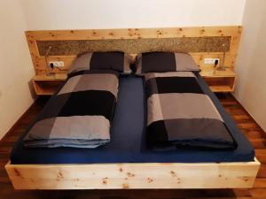 ein Bett mit zwei Kissen auf einem Zimmer in der Unterkunft Ferienwohnung Plattner in Schmirn