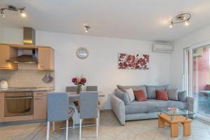 eine Küche und ein Wohnzimmer mit einem Sofa und einem Tisch in der Unterkunft Apartment Percic with Shared Pool in Vabriga