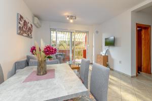 a dining room table with a vase of flowers on it at Apartment Percic with Shared Pool in Vabriga