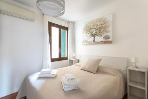 Un dormitorio blanco con una cama con toallas. en Palazzina San Polo 2151, en Venecia