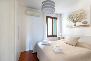 um quarto branco com uma cama com toalhas em Palazzina San Polo 2151 em Veneza