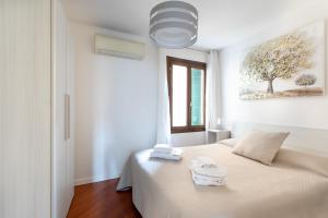 a white bedroom with a bed with towels on it at Palazzina San Polo 2151 in Venice