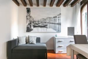uma sala de estar com um sofá e uma pintura na parede em Palazzina San Polo 2151 em Veneza mais 31 fotografias