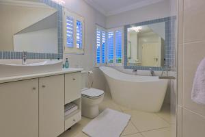 a white bathroom with a tub and a sink at Denhill Villa Unit 4 in Swakopmund