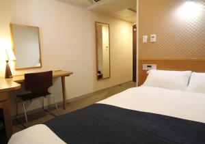 a hotel room with two beds and a desk and a mirror at APA Hotel Kagoshima Chuo-Ekimae in Kagoshima