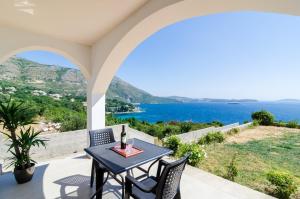 a table and chairs on a patio with a view of the ocean at Apartments A&M in Mlini