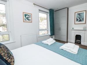 a white bedroom with two beds and a fireplace at Hillside in Dartmouth