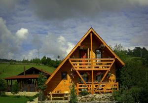 Cette grande maison en bois dispose d'un balcon et d'une terrasse couverte. dans l'établissement Pensiunea Ecosasu, à Gura Humorului