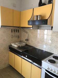 a kitchen with yellow cabinets and a stove top oven at TILIA Apartmet in Struga