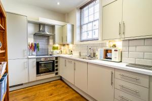 een keuken met witte kasten en witte apparaten bij Middlethorpe Manor - No 4 Relaxation and Peace in York