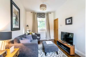 a living room with a couch and a tv at Middlethorpe Manor - No 4 Relaxation and Peace in York