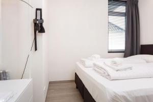 1 dormitorio con 2 camas blancas y ventana en Beneden appartement paviljoenwei 12, Sneek - Offingawier, en Offingawier