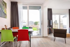 ein Esszimmer mit einem Tisch und bunten Stühlen in der Unterkunft Beneden appartement paviljoenwei 12, Sneek - Offingawier in Offingawier