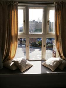 a room with a window and a bed with pillows at Castle Hotel & Apartments in Lincoln