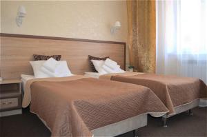 ムーロムにあるГостиница Святогор с русской банейのベッド2台が備わるホテルルーム内のベッド2台
