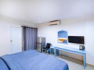 a hotel room with a bed and a desk at Chateau Hotel & Apartments in Pathum Thani