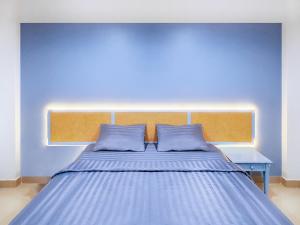 Chateau Hotel & Apartments في محافظة باثوم ثاني: غرفة نوم زرقاء مع سرير بجدار ازرق